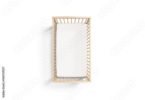 Blank wood cot with white crib sheet mockup, top view photo