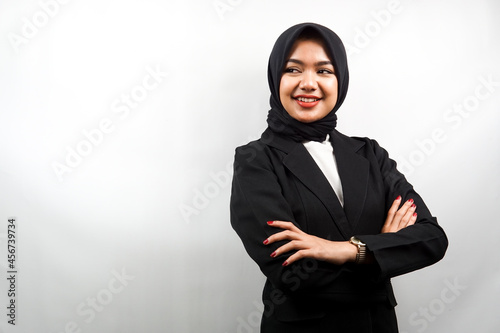 Beautiful young asian muslim business woman confident and cheerful looking empty space presenting something, isolated on white background