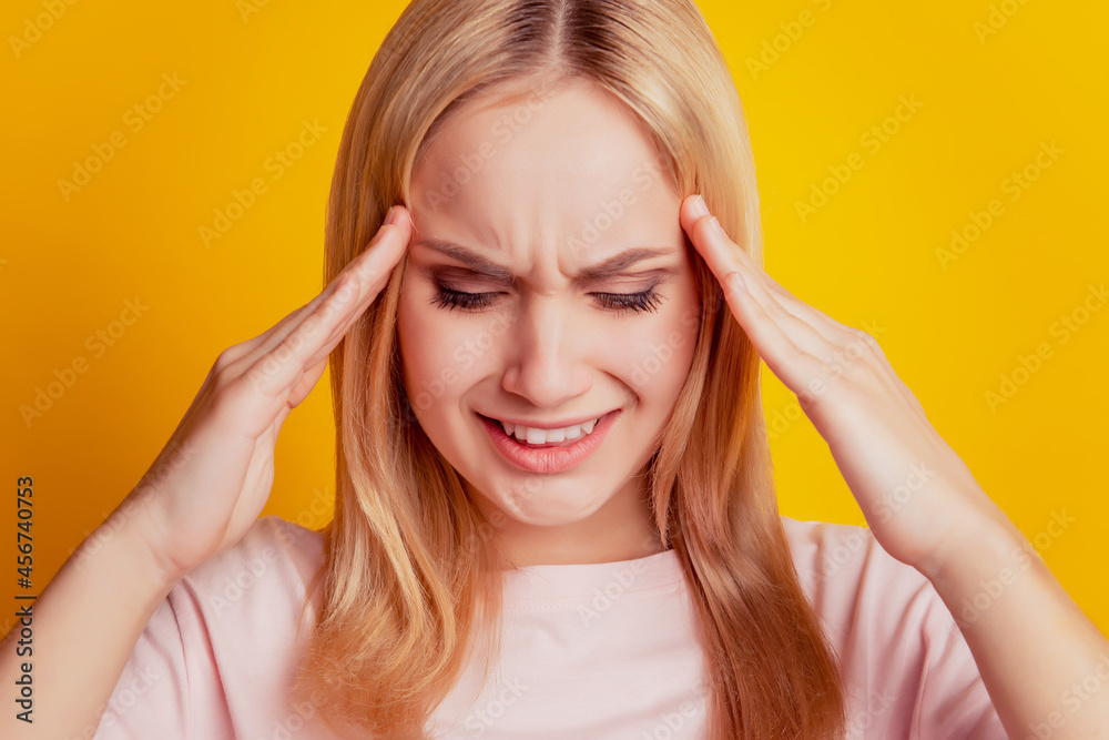 Portrait of troubled suffering girl hands head have headache on yellow background Portrait of troubled suffering girl hands head have headache on yellow background