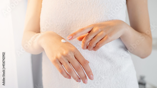 Wallpaper Mural Hand treatment. Female beauty. Nourishing care. Unrecognizable woman covering in towel applying cream on arm in light window room interior. Torontodigital.ca
