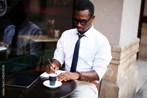 Businessman drinking coffee in cafe. Handsome African man enjoying in fresh coffee.