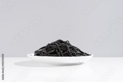 Bowl of black pasta on white shelf photo