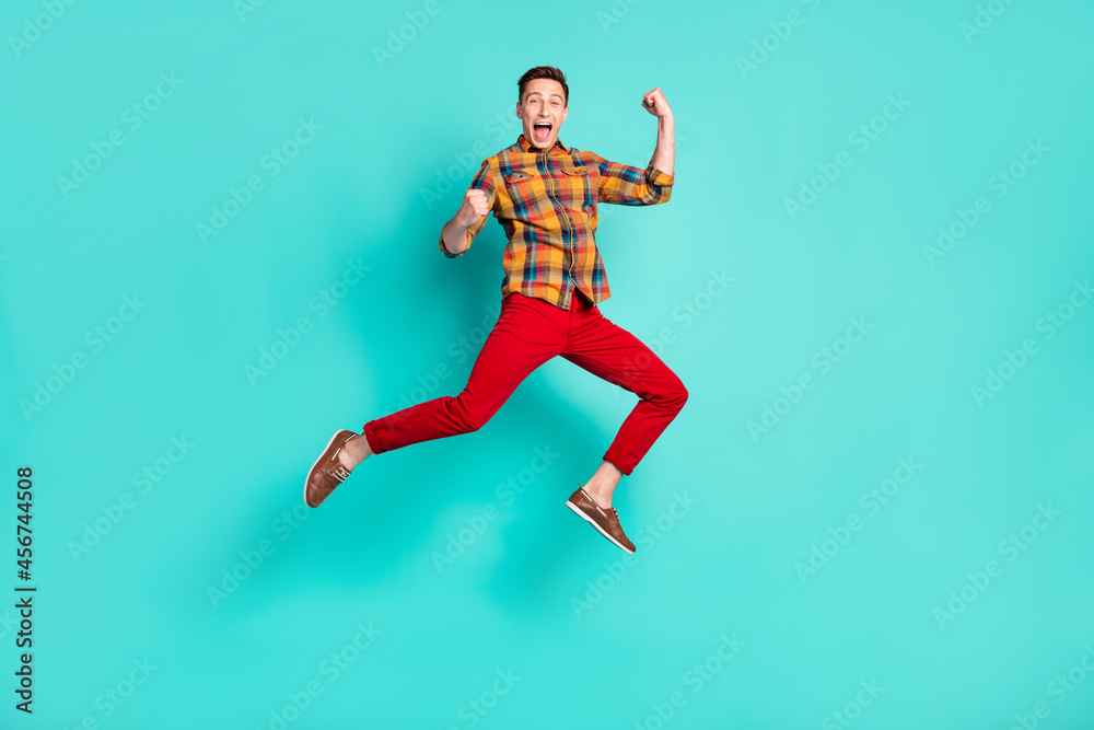 Full body photo of funky brunet millennial guy jump wear shirt turquoise sneakers isolated on teal background