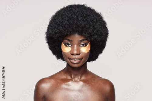Portrait of beautiful young African woman with patches near eyes looking at camera