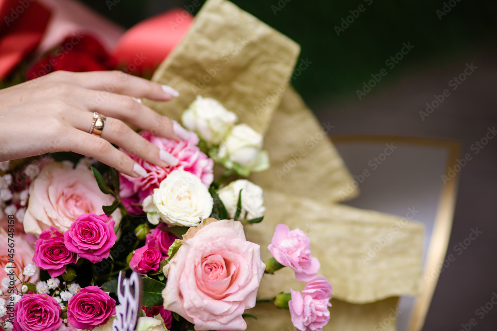 hand of the bride with a wedding ring holding a large bouquet of flowers. wedding day. hand of the bride with a wedding ring holding a large bouquet of flowers. wedding day.