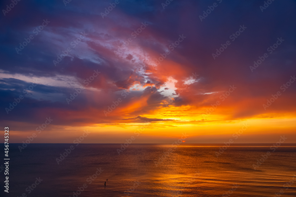 Colorful sunset at the Baltic Sea. Swimming couple in a bright sunset. 