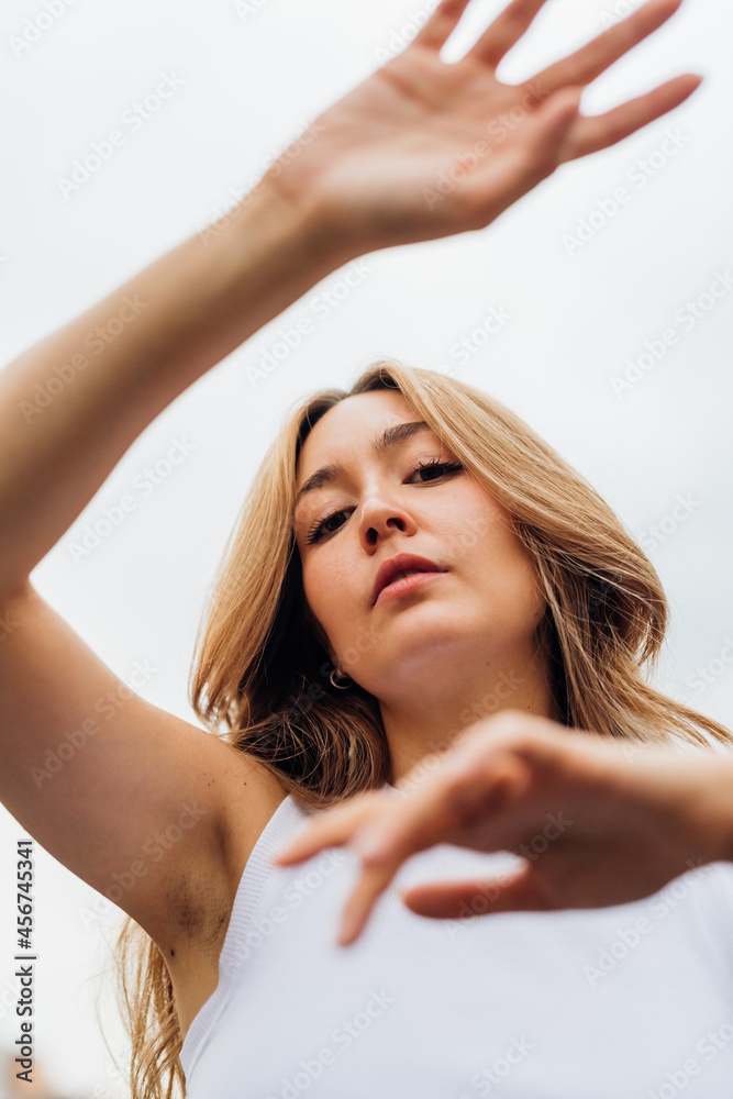 Fototapeta premium Young caucasian woman dancing outdoor gesturing with hands feeling free
