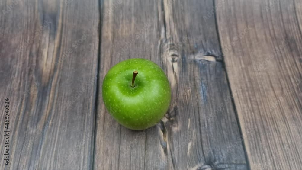 The Natural Green apple on a wooden background close-up. The Natural Green apple on a wooden background close-up.