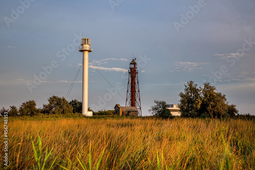 Sea lighthouse on the island of Dzharylhach at sunset. photo