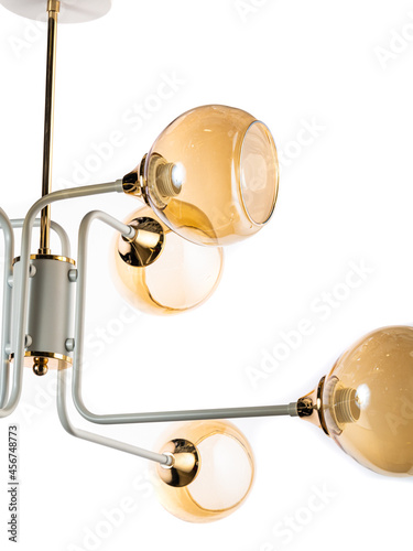 yellow gold chandelier with decorations hanging on a white background