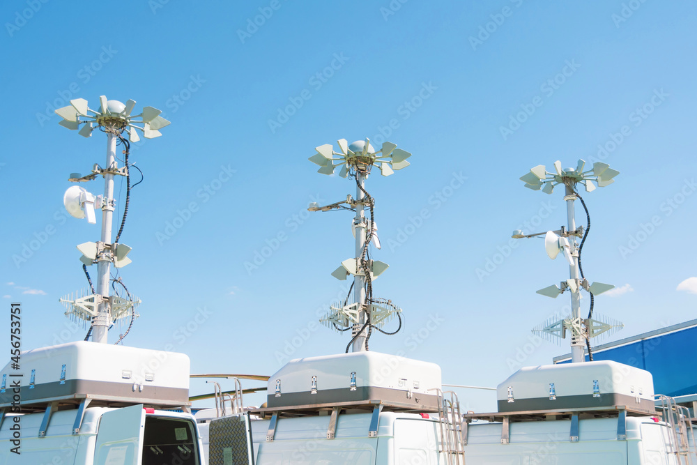 Three powerful mobile antennas on the roofs of a van car for communication or location observation in the immediate radius of the space, mobile point of movement.