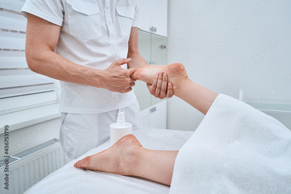 Woman receiving a relaxing foot massage performed by an acupressurist Woman receiving a relaxing foot massage performed by an acupressurist