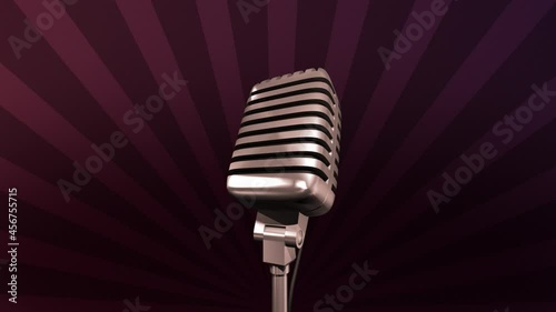 Golden retro microphone rotating on a stand. Rays are spinning on an dark background. Seamless looping