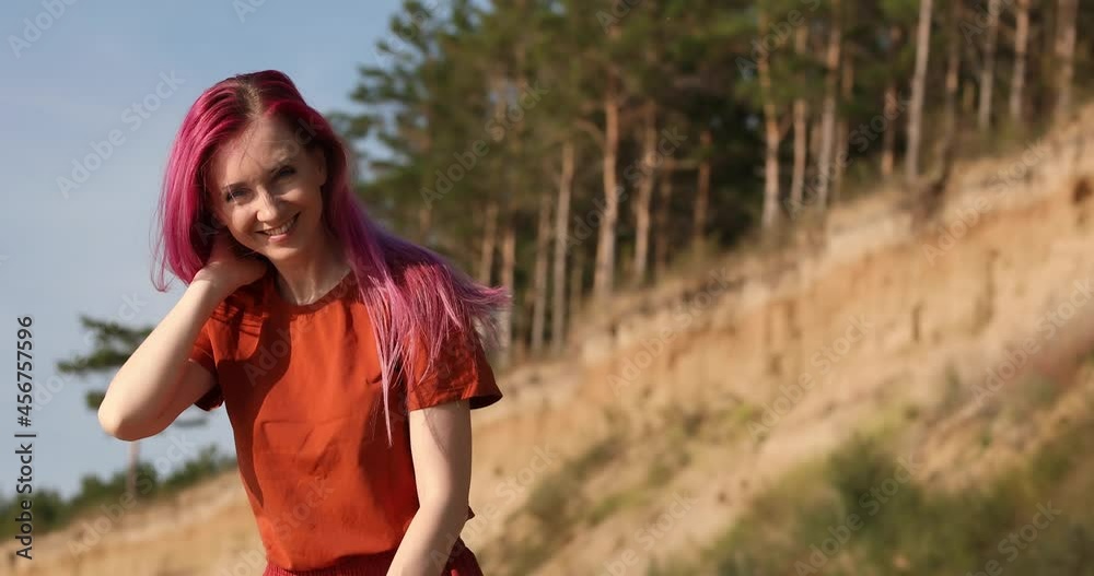 woman with pink hair enjoying the sun and wind on the beach woman with pink hair enjoying the sun and wind on the beach