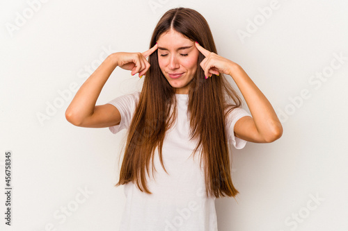 Young caucasian woman isolated on white background focused on a task, keeping forefingers pointing head.