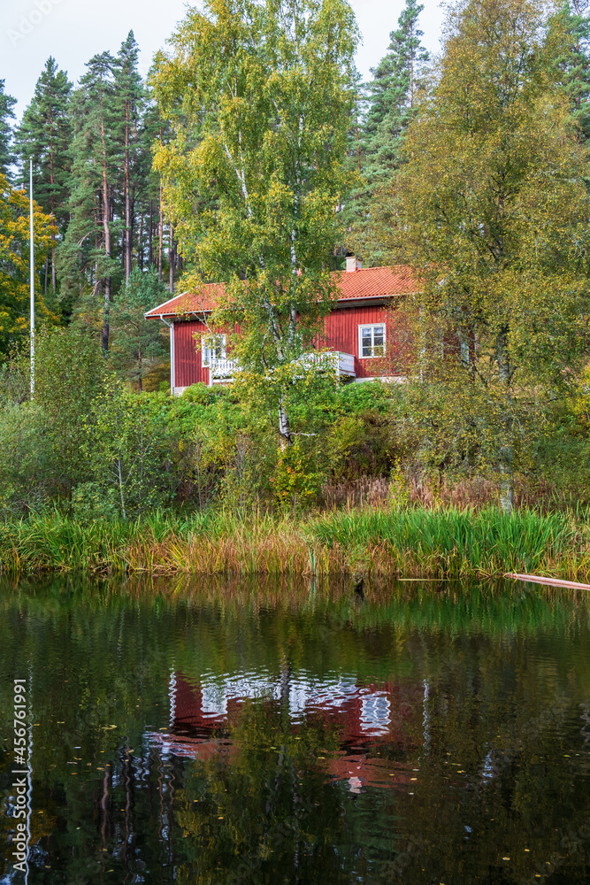 Fototapeta premium Red cottage by a forest lake