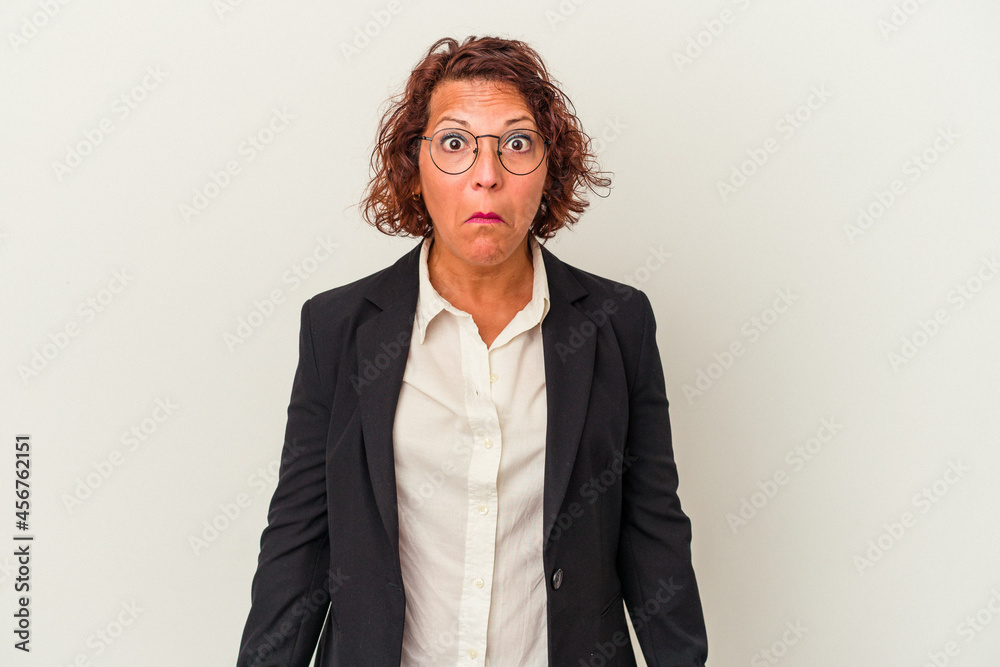 Middle age latin business woman isolated on white background shrugs shoulders and open eyes confused. Middle age latin business woman isolated on white background shrugs shoulders and open eyes confused.