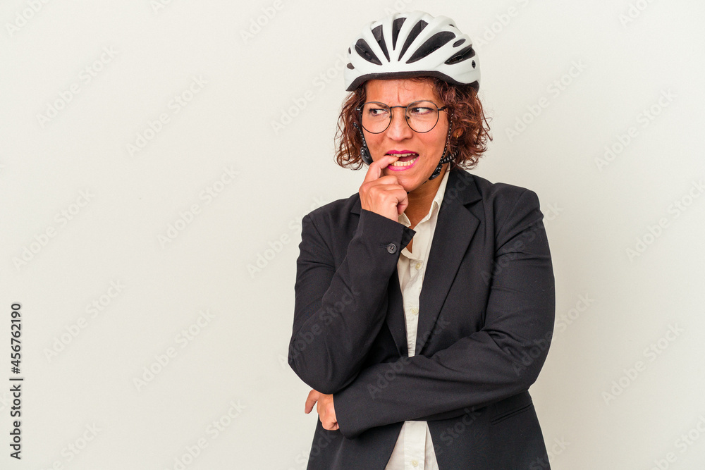 Middle age latin business woman wearing a bike helmet isolated on white background relaxed thinking about something looking at a copy space. Middle age latin business woman wearing a bike helmet isolated on white background relaxed thinking about something looking at a copy space.