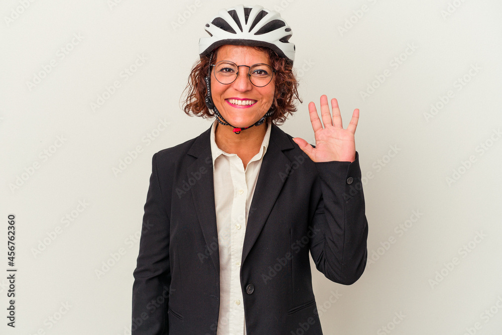 Middle age latin business woman wearing a bike helmet isolated on white background smiling cheerful showing number five with fingers.
