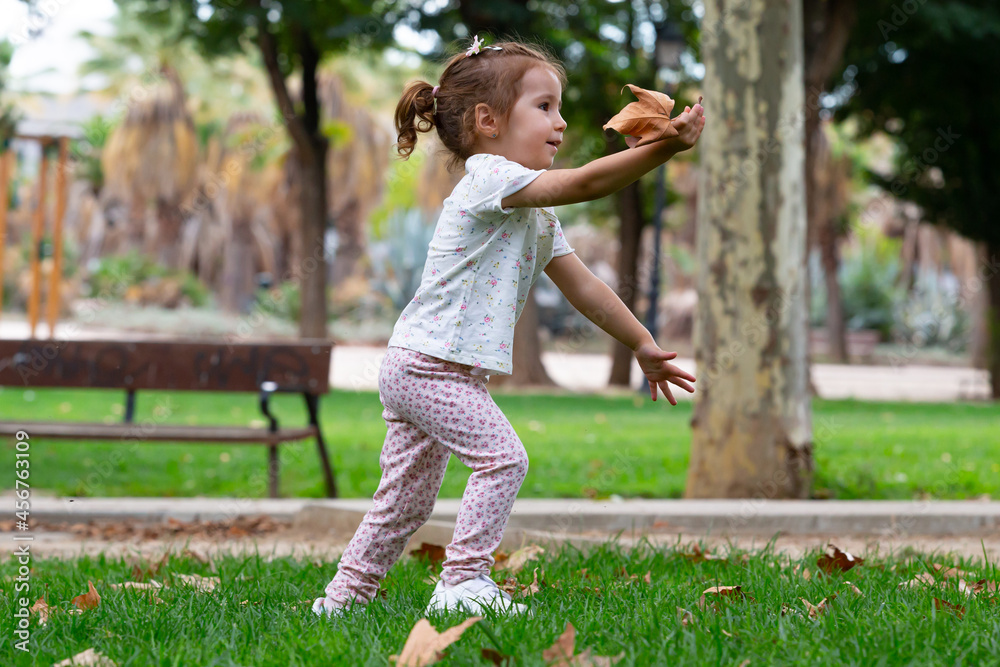 Little girl picking up autumn leaves in the park Little girl picking up autumn leaves in the park