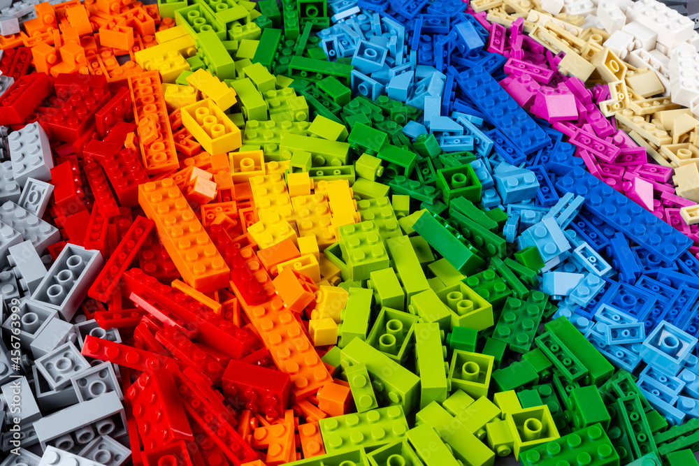 top view pile of many various colorful rainbow colored stackable plastic toy bricks. childhood education development concept
