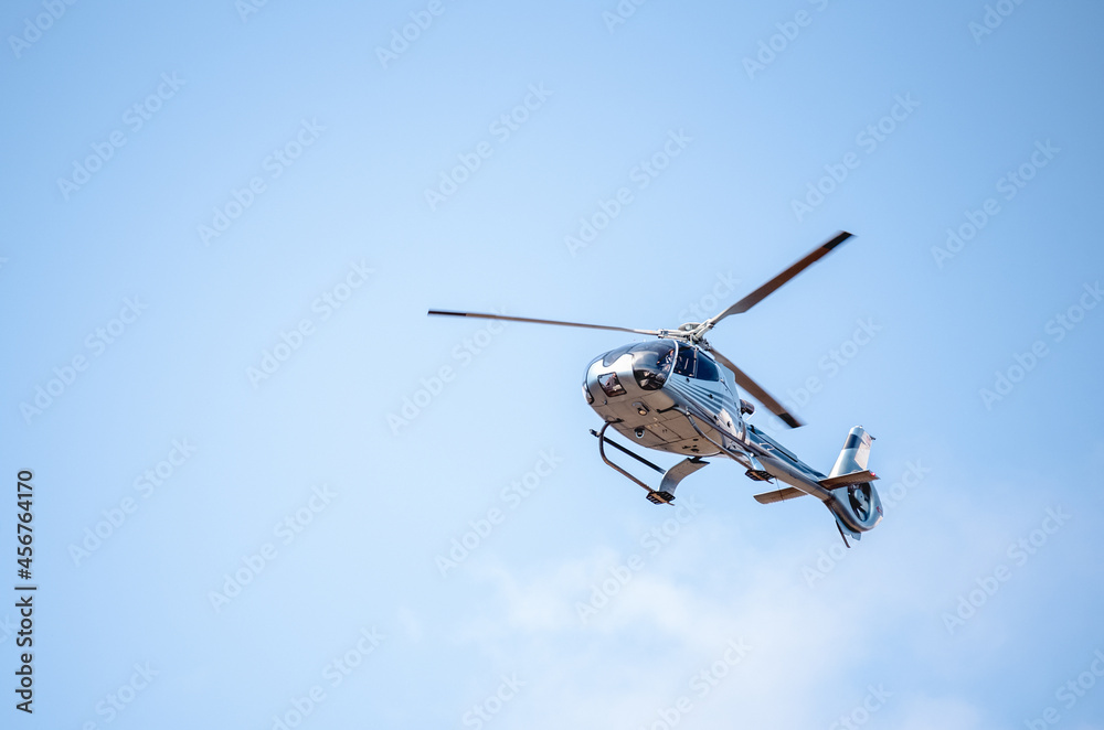 Flying helicopter in blue sunny sky - obrazy, fototapety, plakaty 