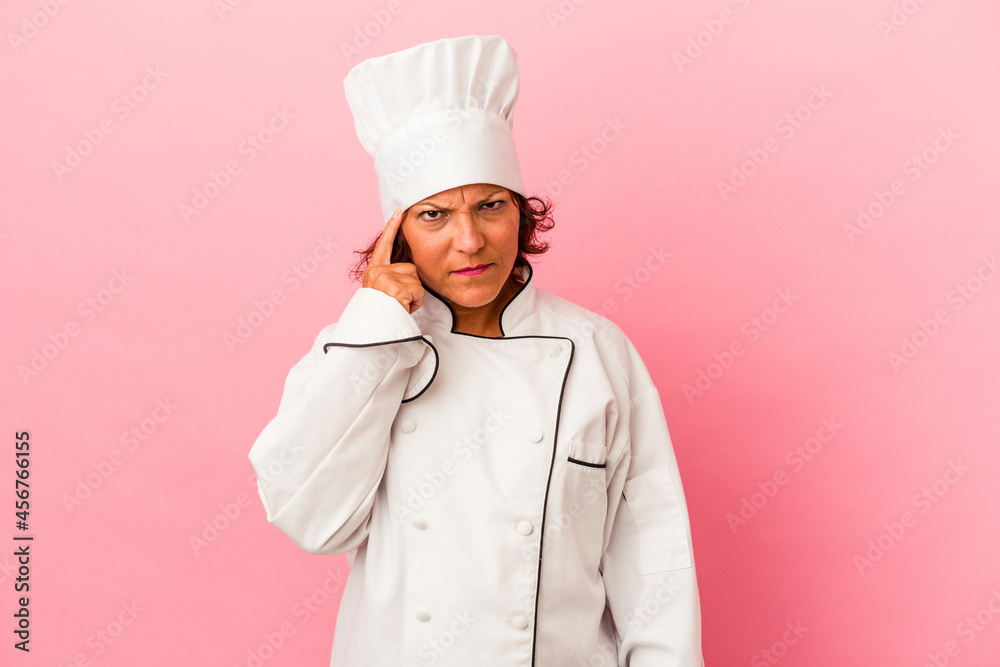 Middle age latin woman isolated on pink background pointing temple with finger, thinking, focused on a task. Middle age latin woman isolated on pink background pointing temple with finger, thinking, focused on a task.