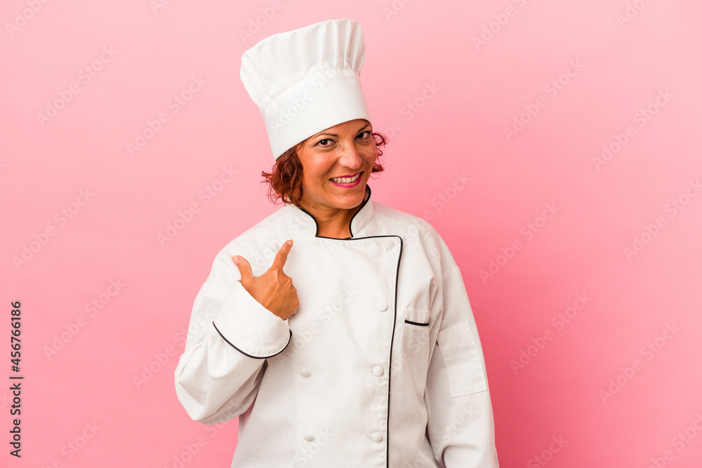 Middle age latin woman isolated on pink background pointing with finger at you as if inviting come closer. Middle age latin woman isolated on pink background pointing with finger at you as if inviting come closer.