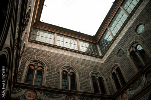 Below shot of a interesting architecture old building with reflection in mirrors on a cloudy day