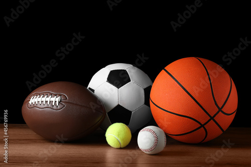 Set of different sport balls on wooden surface