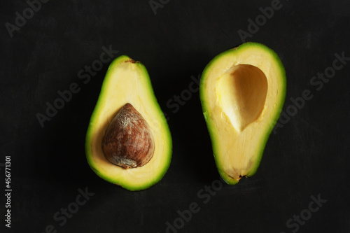 .Cut avocado on a black background. Horizontal orientation