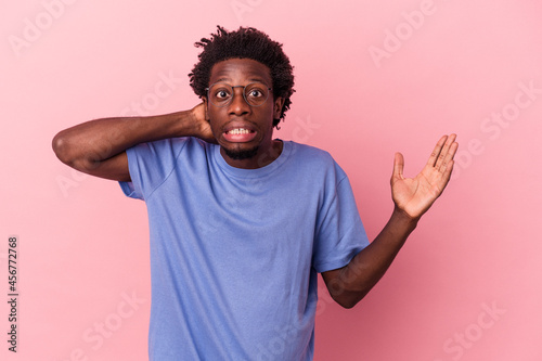 Young african american man isolated on pink background screaming with rage.