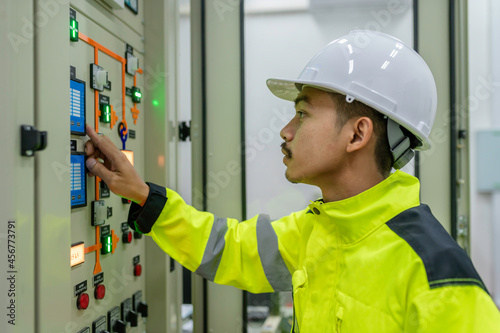 Electrical engineer man checking voltage at the Power Distribution Cabinet in the control room,preventive maintenance Yearly,Thailand Electrician working at company