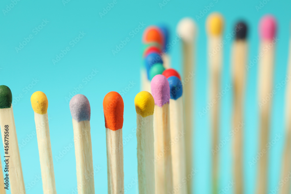 Matches with colorful heads on light blue background, closeup Matches with colorful heads on light blue background, closeup