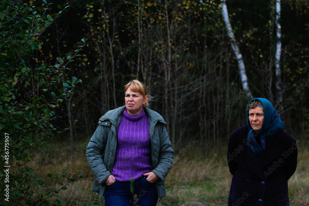 Defocus two woman standing in pine forest. Leisure and people concept, mother and daughter in fall forest. People lost. lifestyle. Out of focus Defocus two woman standing in pine forest. Leisure and people concept, mother and daughter in fall forest. People lost. lifestyle. Out of focus