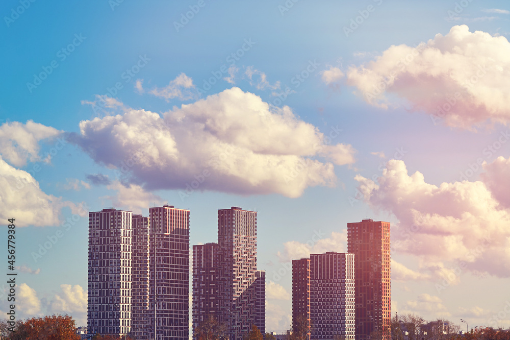 High-rise multi-storey new houses in a modern city against the background of a blue sky with clouds