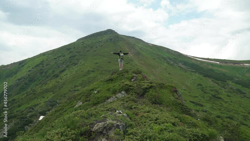 Man traveler experiences emotions while on top of a mountain Man traveler experiences emotions while on top of a mountain