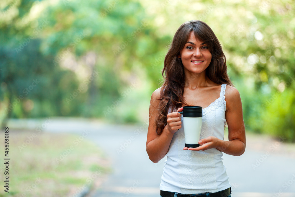 Beautiful young woman with a disposable coffee cup, drinking coffee in her hands Beautiful young woman with a disposable coffee cup, drinking coffee in her hands