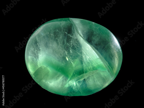 Fényképezés Fluorite tumbled stone isolated on black and backlit