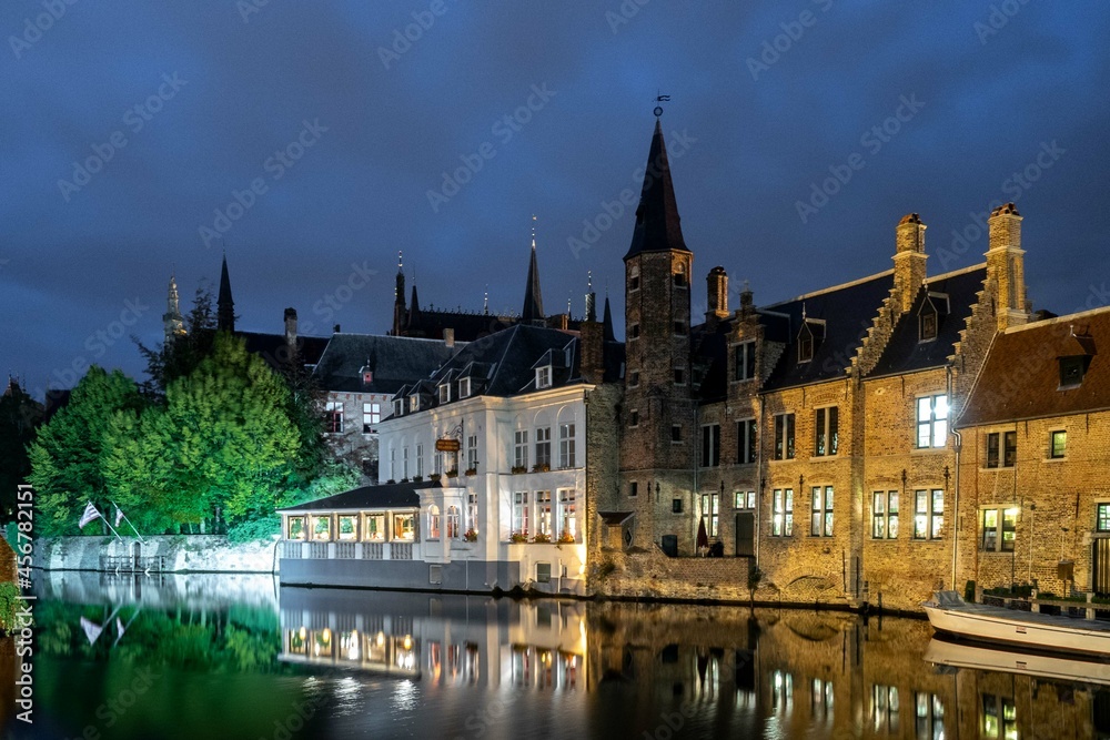 Bruges, Belgium. September 30, 2019: Muelle del Rosario at night and reflection in the water of the canal.