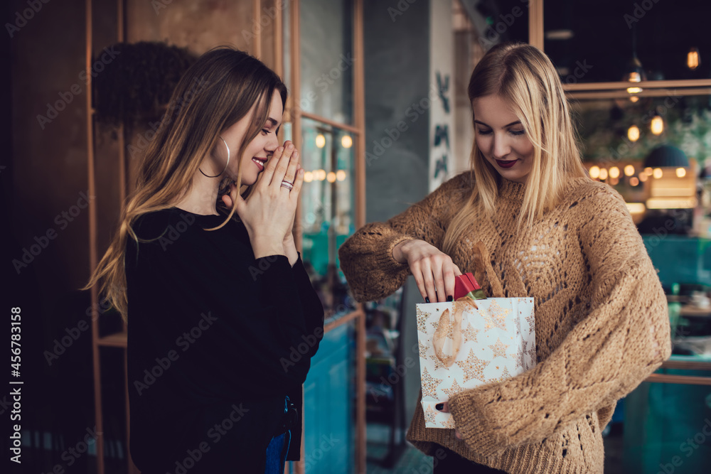 Fototapeta premium Young happy women opening presents at home
