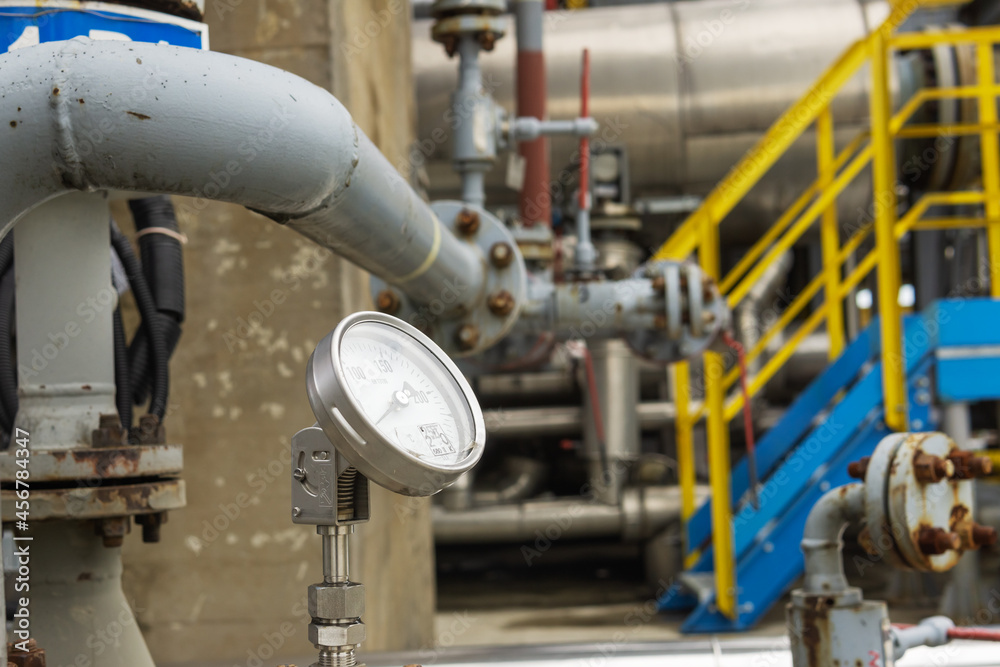 Industrial pressure gauge on the background of a chemical plant. Pressure gauge readings.