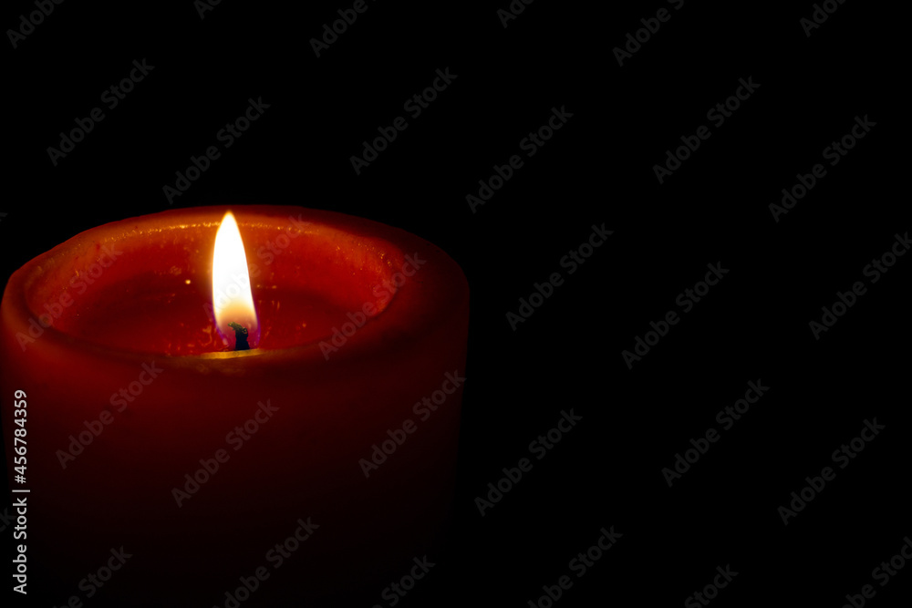 Candle flame in the dark. Burning red candle on a black background. Candle flame in the dark. Burning red candle on a black background.