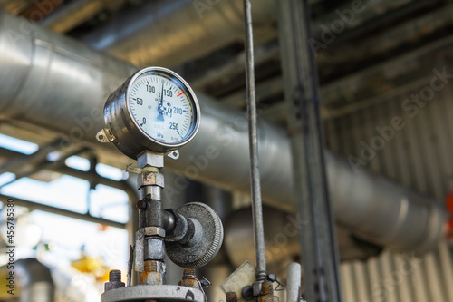 Industrial pressure gauge on the background of a chemical plant. Pressure gauge readings.