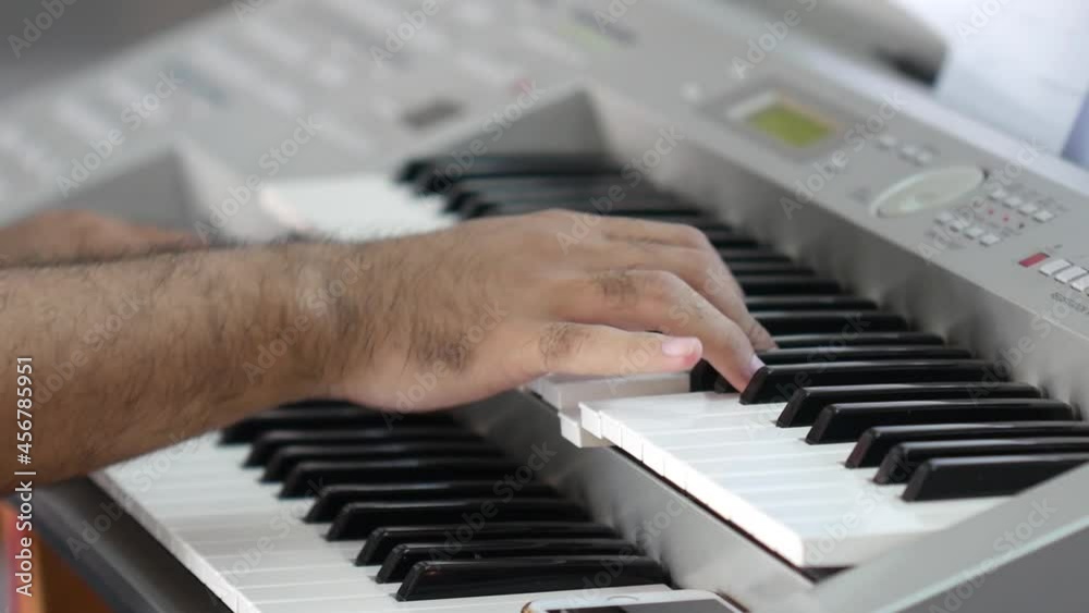 A man's hand is playing the keyboard keys. The concept of playing musical instruments A man's hand is playing the keyboard keys. The concept of playing musical instruments