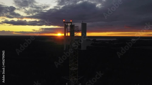 Aerial view closely around a radio tower, during sunset - orbit, drone shot