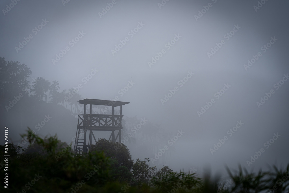 Military Wooden watch tower in the jungle surrounded by mystic fog. Dangerous concept 