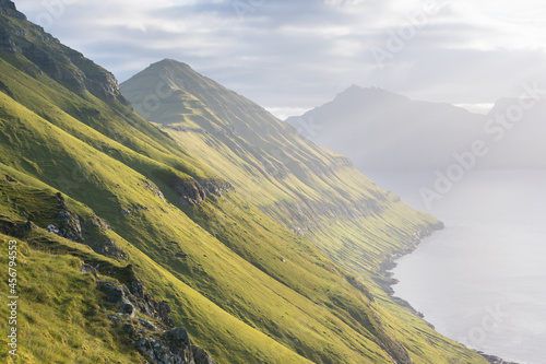 The top of the mountain of Faroe islands. A view of high peaks of mountains on a sunny day. Ocean view. Beautiful panoramic view. Northern Europe. Travel concept