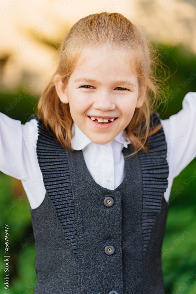 a cute girl in a gray school uniform. sale of clothes for schoolchildren. a cute girl in a gray school uniform. sale of clothes for schoolchildren.