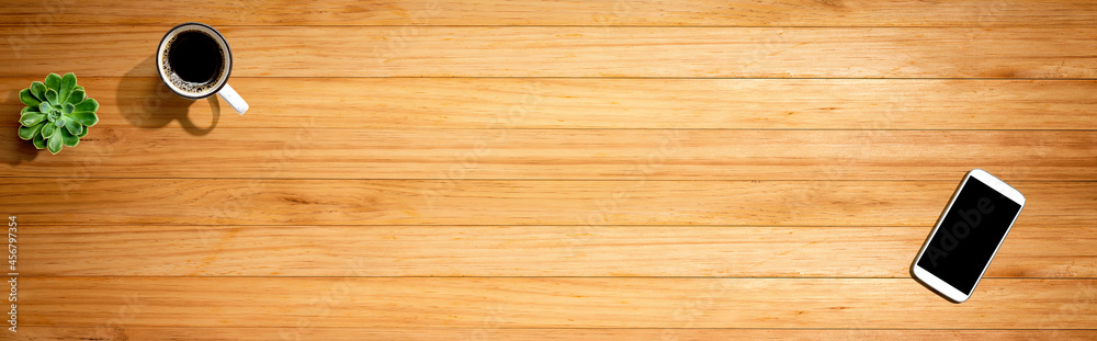 Fototapeta premium Smartphone with a coffee mug and succulent plant - flat lay